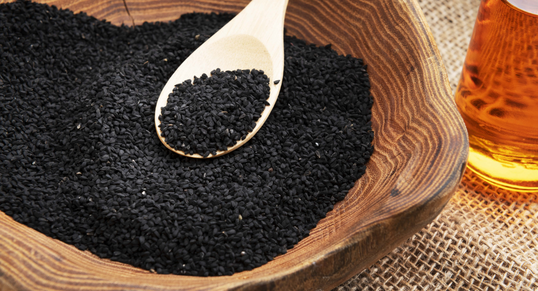 a wooden spoon in a bowl of black seeds